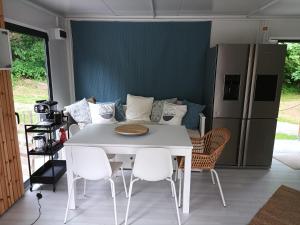 ein Esszimmer mit einem weißen Tisch und Stühlen in der Unterkunft OFFGRID Haus am Angelteich 