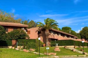 un bâtiment avec un palmier en face dans l'établissement Residence Azzurro Calaghena, à Montepaone