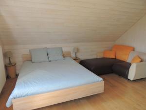 DochampsにあるAuberge "La Fourchette Paysanne"の小さなベッドルーム(ベッド1台、ソファ付)