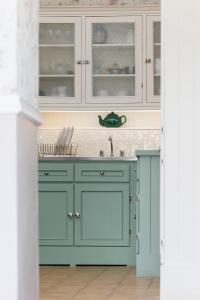 una cocina con armarios azules y fregadero en Suir Valley Cottage. 