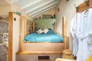 um quarto com uma cama com um edredão azul em The Olde Piggery, on the coast, Zennor, St Ives em Zennor