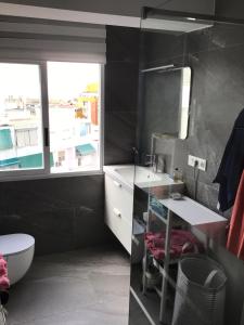 uma casa de banho com um lavatório, um WC e uma janela. em Le Montemar em Alicante