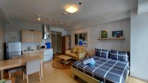 a living room and a kitchen with a bed in a room at N place at Soho Central in Manila