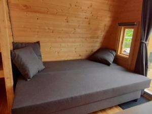 a bed in a log cabin with a window at Logement insolite Pod Lo Tchan in Fréland