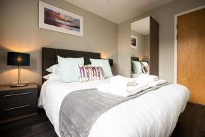 a bedroom with a large bed with towels on it at Urban Living's - The Wren Beautiful City Centre Apartment with Parking in Oxford