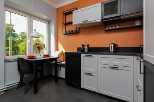 uma cozinha com armários brancos e uma pequena mesa em Apartment Bialobrzeska Warsaw by Renters em Varsóvia