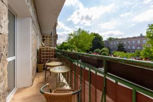 einen Balkon mit Tischen und Stühlen auf einem Gebäude in der Unterkunft Apartment Bialobrzeska Warsaw by Renters in Warschau