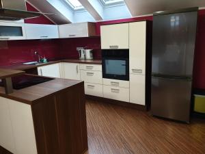 a kitchen with white cabinets and a black refrigerator at Hiša Bizjak in Kranj