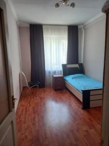 a small bedroom with a bed and a wooden floor at Malacia apartments in Yerevan
