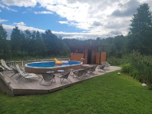 una terraza con sillas y una piscina en el patio trasero en Neitsijärve majutus en Otepää