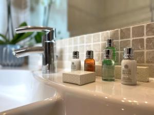 a bathroom sink with bottles ofodorizers sitting on it at Morgans Hotel in Swansea