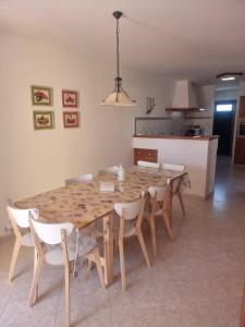 a dining room table with chairs and a kitchen at Casa familiar con piscina, cerca de la playa in Ciutadella