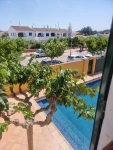 vista para uma piscina a partir de um edifício com árvores em Casa familiar con piscina, cerca de la playa em Ciutadella