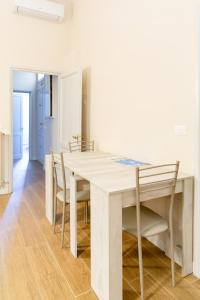 een witte eetkamer met een tafel en stoelen bij Comfy Apartment Near Fortezza Da Basso in Florence