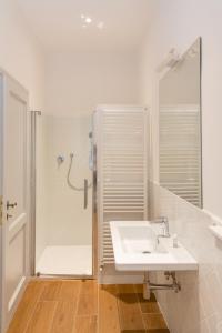 een witte badkamer met een wastafel en een douche bij Comfy Apartment Near Fortezza Da Basso in Florence