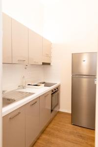 een keuken met witte kasten en een roestvrijstalen koelkast bij Comfy Apartment Near Fortezza Da Basso in Florence
