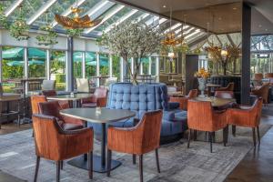 un restaurante con mesas y sillas y un sofá azul en Slaley Hall Hotel, Spa & Golf Resort, en Slaley