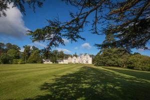 a large grassy field in front of a large house at Lough Rynn Castle in Mohill