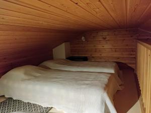 Habitación con 2 camas en una cabaña de madera en Rukan Mestari en Ruka