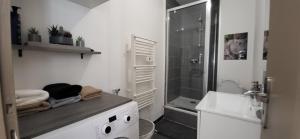 a white bathroom with a shower and a sink at Résidence du soleil in Béziers