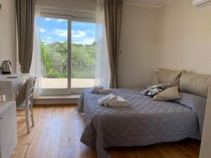 a bedroom with a bed and a large window at Podere Belsogno-Camera rosmarino in Montalcino