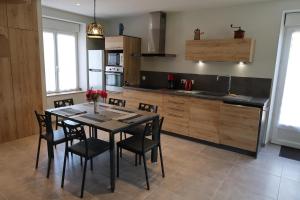 a kitchen with a table and chairs in a room at Le Sophora in Chéu