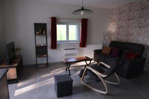 ein Wohnzimmer mit einem Sofa und einem Tisch in der Unterkunft Le Sophora in Chéu