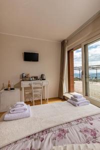 a bedroom with two beds and a desk and a window at Podere Belsogno-Camera rosmarino in Montalcino