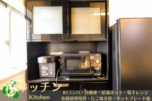 a microwave in a kitchen with an asian writing on it at WADACHI in Osaka
