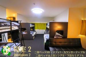 a room with several bunk beds in it with a light at WADACHI in Osaka