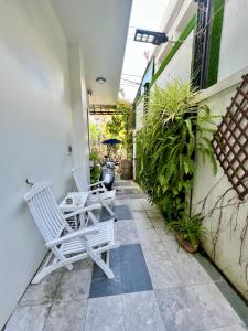 two white chairs on a patio with plants at Ngo House Villa in Hoi An