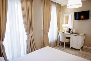 a hotel room with a desk and a bed at Palace Hotel & SPA in Durrës