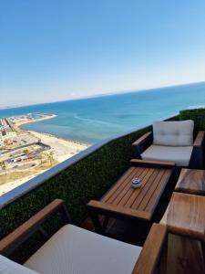 a balcony with a table and chairs and the beach at Absolut Vollga in Durrës
