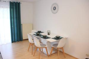 a white dining room with a white table and chairs at Moderne Ferienwohnung in Schwandorf in Schwandorf in Bayern