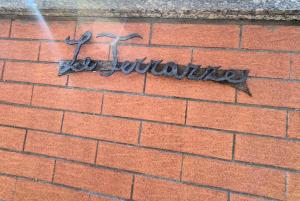 a sign on the side of a brick wall at Beinasco Apartment - Le Terrazze Palace in Beinasco