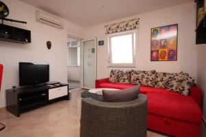 een woonkamer met een rode bank en een tv bij Apartments with a parking space Valbandon, Fazana - 7258 in Fondole