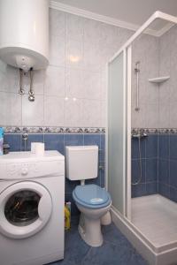 een badkamer met toilet en wasmachine bij Apartments with a parking space Valbandon, Fazana - 7258 in Fondole