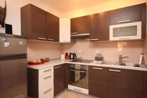 een keuken met houten kasten en roestvrijstalen apparatuur bij Apartments with a parking space Valbandon, Fazana - 7258 in Fondole