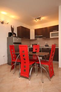 een keuken met rode stoelen en een houten tafel bij Apartments with a parking space Valbandon, Fazana - 7258 in Fondole +10 foto's