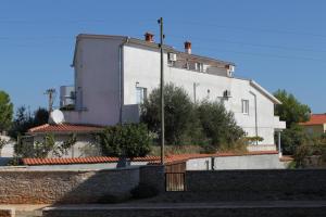 un bâtiment blanc avec une clôture devant lui dans l'établissement Apartments with a parking space Liznjan, Medulin - 7240, à Ližnjan