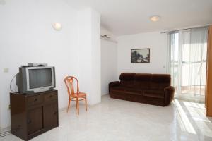- un salon avec un canapé et une télévision dans l'établissement Apartments with a parking space Liznjan, Medulin - 7240, à Ližnjan