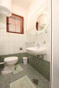 y baño con lavabo, aseo y espejo. en Apartments with a parking space Fazana - 7281 en Fažana