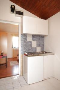 a kitchen with white cabinets and a counter top at Apartments with a parking space Liznjan, Medulin - 7224 in Ližnjan