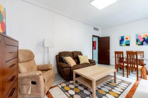 salon z kanapą i stołem w obiekcie Holi-Rent Cuna w Sewilli