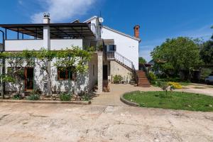 Casa blanca con balcón y entrada en Family friendly apartments with a swimming pool Sisan, Medulin - 7243, en Šišan