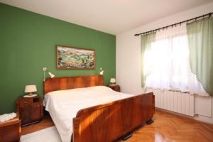 1 dormitorio con cama y pared verde en Apartments with a parking space Fazana - 7283 en Fažana
