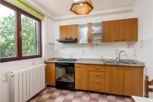 una cocina con fregadero y estufa horno superior en Family friendly apartments with a swimming pool Sisan, Medulin - 7243, en Šišan