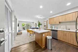 a kitchen with wooden cabinets and a dining room at Beautiful Beachside Apartment With Marina View in Los Angeles