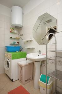 a bathroom with a sink and a washing machine at Apartment Peroj 7254b in Vodnjan