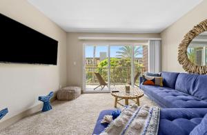 Beautiful Beachside Apartment With Marina View في لوس أنجلوس: غرفة معيشة مع أريكة زرقاء وتلفزيون بشاشة مسطحة
